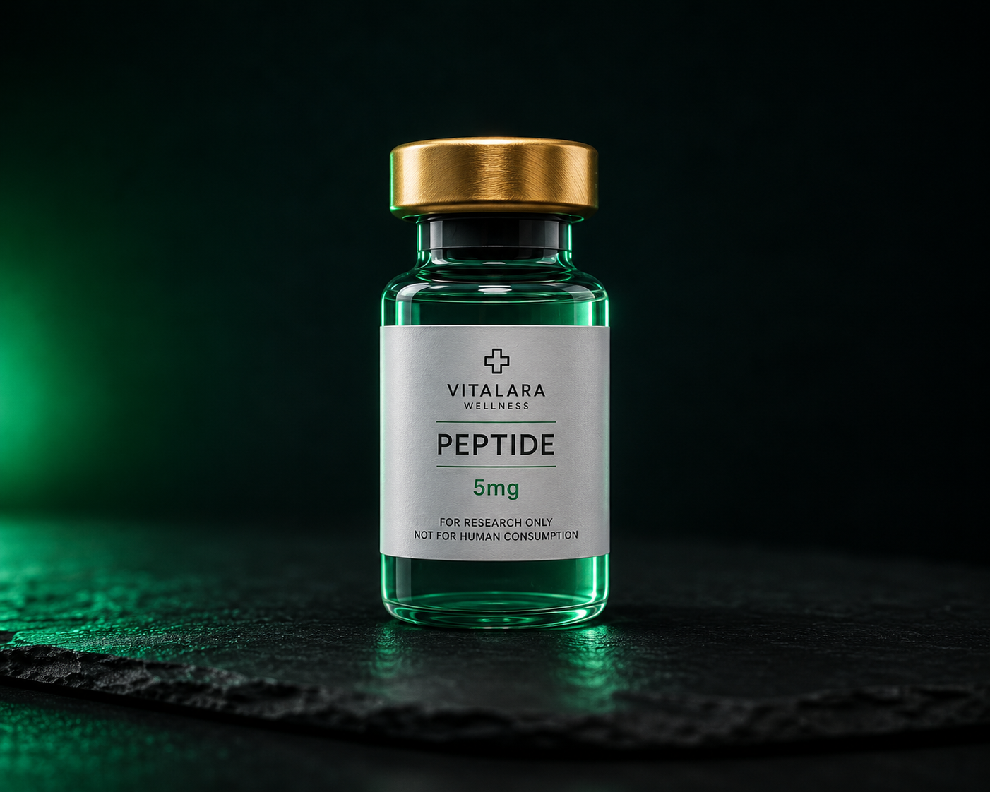 Medical peptide vial with brushed gold cap and emerald liquid on a dark slate background
